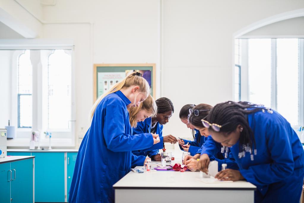Six sixth form students gather around a desk, undertaking chemistry experiments in one of the newly refurbished science labs at Cheltenham Ladies' College.