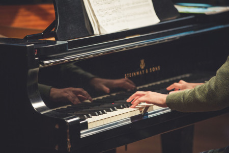 Hands playing a piano